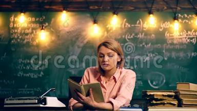 老师有兴趣在一个绿色学校董事会的背景下在学校教室里读一本书。 教师